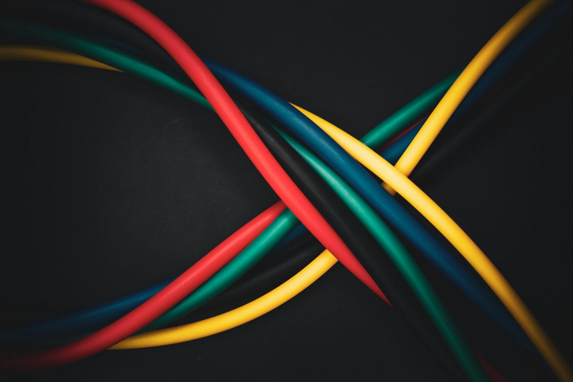 Multi-colored cables intertwined against a dark background, showing technology connections.