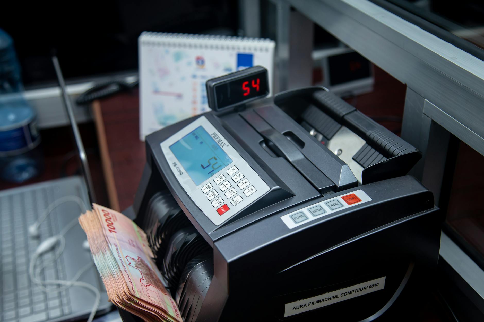 Automatic money counter in a modern office counting banknotes efficiently.