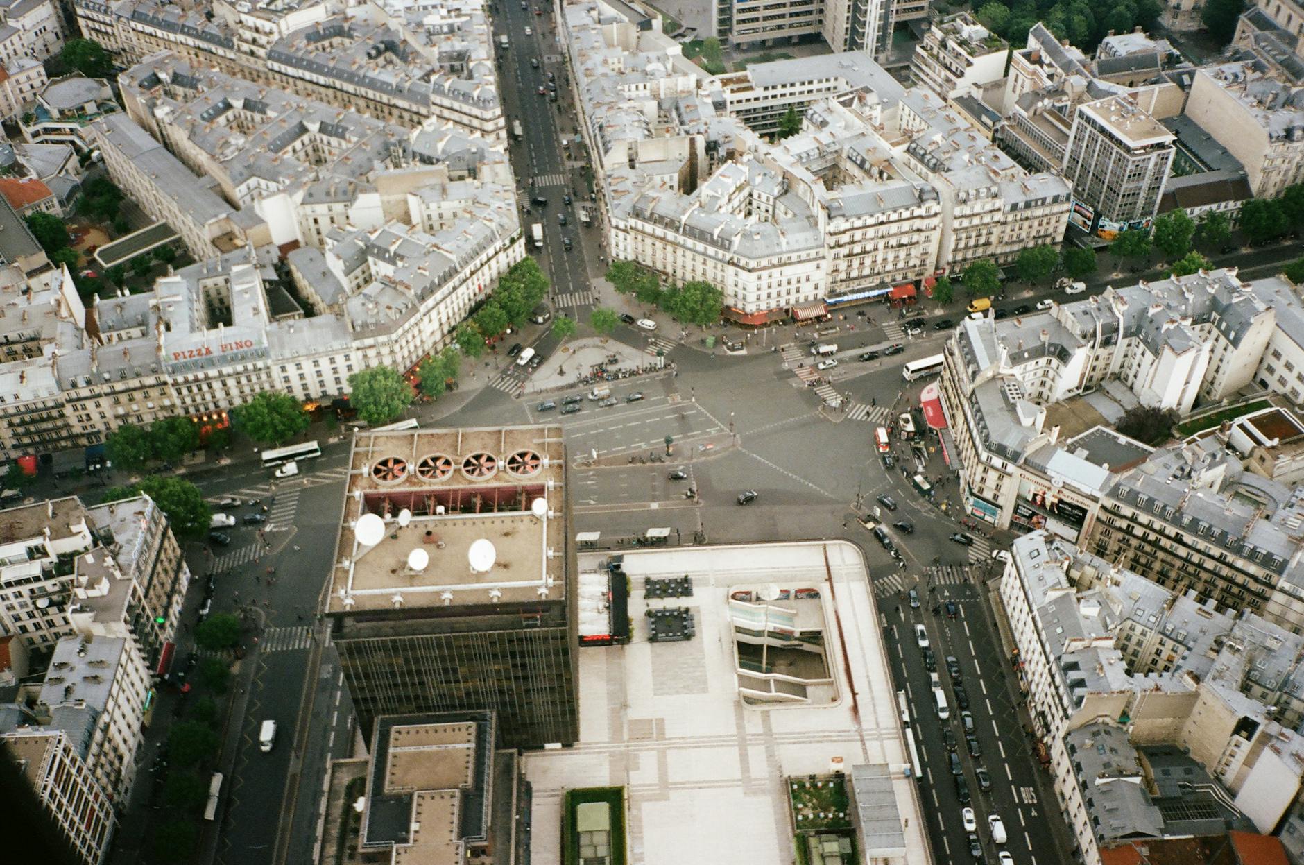 Aerial shot of a bustling urban intersection surrounded by historic buildings and roads.